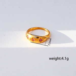 Detalle del anillo de acero inoxidable dorado de 7,5mm con tres circonitas rosa en estrella