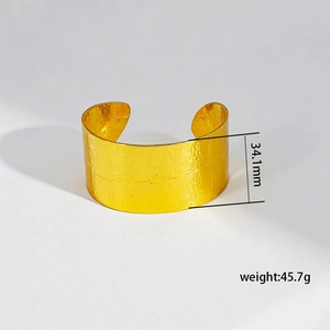 Macro detail of gold adjustable cuff bracelet showing hammered texture and dimensions