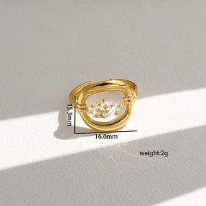 Detailed view of handmade stainless steel ring with white dried flower in gold oval frame