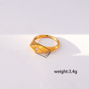Detalle de anillo de acero dorado de 7 mm con grabado de estrella y piedra engastada