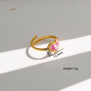 Detail view of heart-shaped gold ring featuring pink preserved flower inlay and dimensions