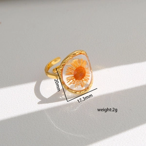 Detailed view of handmade dried orange flower embedded in clear resin ring with dimensions