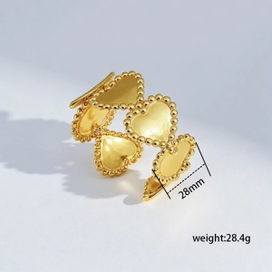 Detail showing 28mm golden heart segments with milgrain edges on a textured bangle