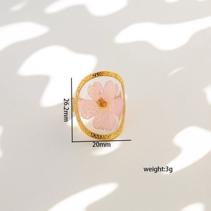 Detail view of pink pressed flower ring in gold frame with 26.2mm height and 3g weight