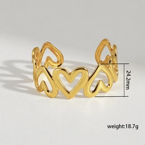 Close-up of golden hollow heart pattern open cuff bangle with size and weight specs