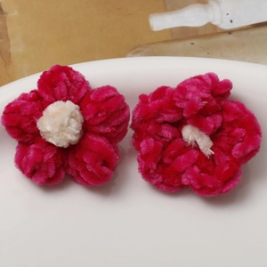 Detail of handcrafted pink and white plush puff flowers for DIY jewelry making