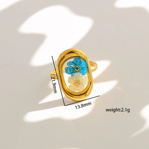 Detailed view of gold oval ring with dried flowers showing 21.9mm by 13.8mm dimensions