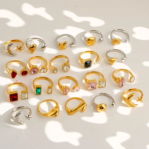 Flat lay of diverse gold and silver open rings with colorful gemstone and geometric charms
