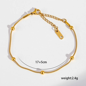 Dettaglio del bracciale a catena serpente dorata con cinque perline e chiusura a moschettone