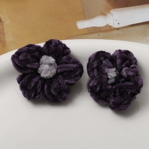 Detailed close-up of handmade purple chenille crochet puff flowers for DIY accessories