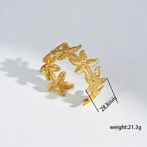 Macro shot of gold floral titanium steel cuff with 28.8mm flower texture detail