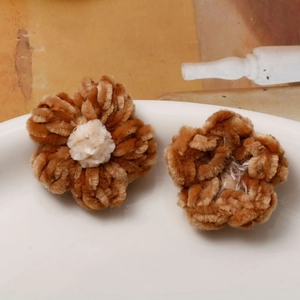 Detailed view of handmade plush puff flower accessories in brown chenille texture