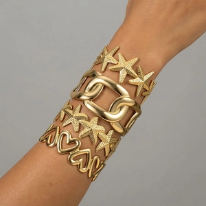 Set of four gold titanium bracelets featuring starfish and heavy texture floral designs