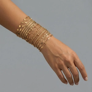 Ensemble de bracelets dorés en acier inoxydable avec cœurs gravés Love portés par un modèle