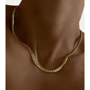 Detailed view of a gold flat curb chain necklace worn on the neck with metallic luster