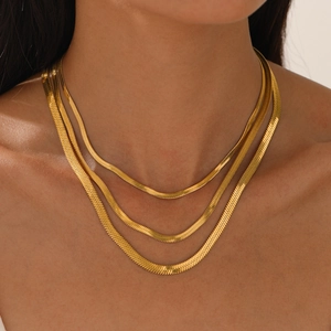 Exquisite detail of layered gold stainless steel snake chain necklace worn on the neck