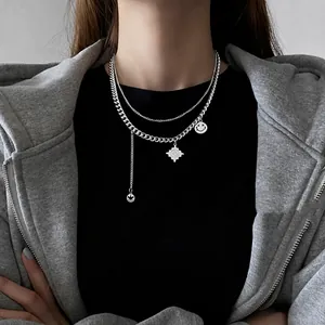 Double-layered silver smiley face necklace with chunky Cuban chain and tassel detail