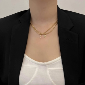 Collier double épaisseur en acier titane doré avec pendentifs lettres L et R en zircon