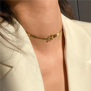 Golden snake chain choker with belt buckle design on female model in beige blazer