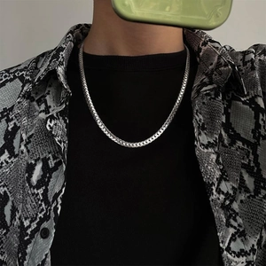 Polished silver titanium steel Cuban chain necklace worn with a snakeskin textured shirt