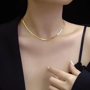 Close-up of a long double-layered golden snake bone necklace on a female model