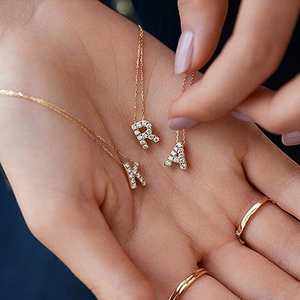 Collana in acciaio al titanio placcato oro 18K con ciondoli a lettera in pavé di zirconi