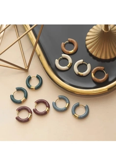 Macro shot of retro enamel hoop earrings in deep green, burgundy, and navy blue