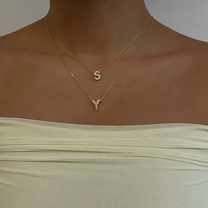 Dettaglio dei ciondoli a doppia catena con lettere S e Y placcati in oro 18K e zirconi