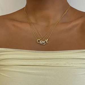 Collana in acciaio al titanio placcato oro 18K con ciondoli a lettere CRSY di diamanti