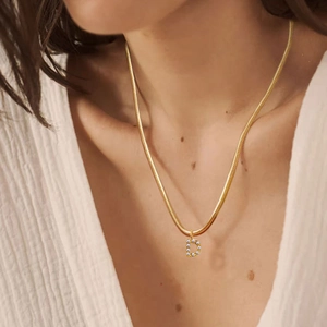 Detailansicht einer goldenen Schlangenkette mit einem perlenbesetzten Buchstaben-D-Anhänger
