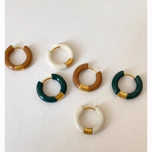Flat lay of vintage gold-plated hoop earrings with glossy brown white and green enamel