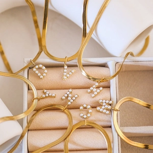 Detailansicht der goldene Schlangenkette mit Perlen-Anfangsbuchstaben auf Samt-Etui