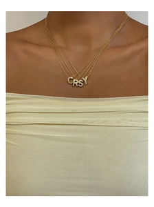 Dettagli di ciondoli con lettere in titanio placcato oro 18K con pavé di zirconi lucidi