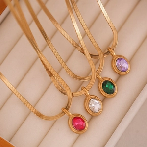 Detail of gold snake chain necklaces with oval zircon pendants in four vibrant colors