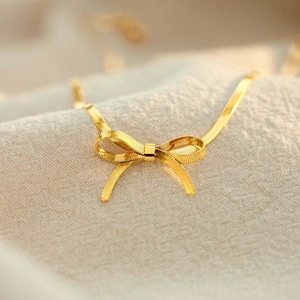 Gold-plated stainless steel snake chain choker featuring a polished bow pendant