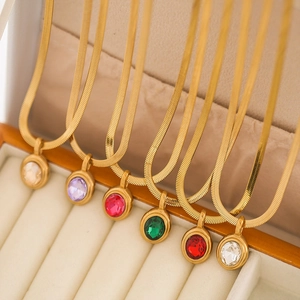 Detail view of gold snake chain necklaces with various colorful oval zircon pendants