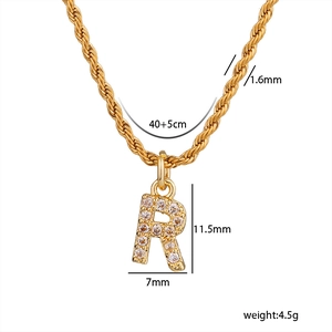 Dettaglio della collana a catena dorata ritorta con pendente lettera R in zirconi