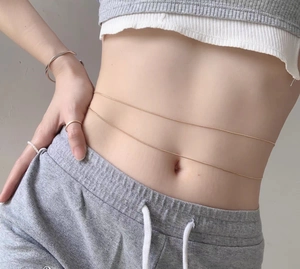 Detailed view of sexy gold double-layer snake chain waist link on model's waist