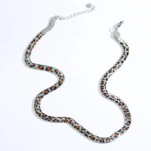 Detail of silver titanium snake chain choker featuring orange and black leopard print pattern