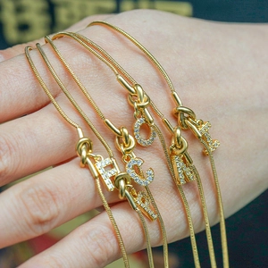 18k vergulde slangketting met letterhangers voorzien van hartknoop en zirkonia