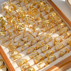 Colección de anillos vintage ajustables de acero inoxidable en un joyero de madera elegante