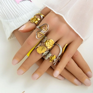 Exaggerated stainless steel mixed metal rings featuring cross and floral motifs