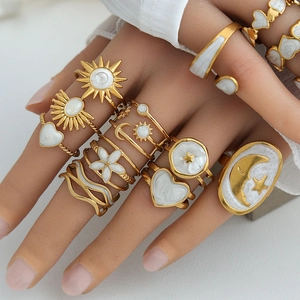Bohemian gold celestial ring set with white enamel sun moon and star motifs on hand