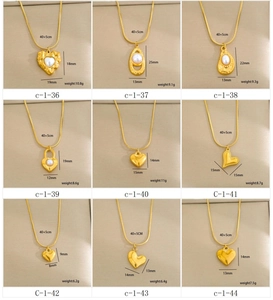 Detalle de collares bañados en oro con colgantes de corazón y perlas con especificaciones