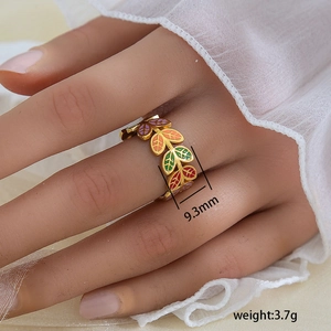 Détail macro de la bague en acier doré de 9,3 mm avec motifs de feuilles en émail coloré