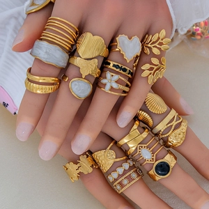Primer plano de conjuntos de anillos bohemios de flores y hojas bañados en oro de 18K