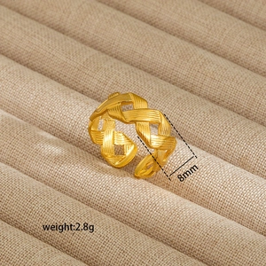 Detail of 8mm gold braided texture open ring showing intricate metallic craftsmanship