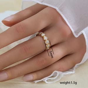 Détail macro d'une bague cœur dorée de 5mm pesant 1,5g avec émail blanc incrusté