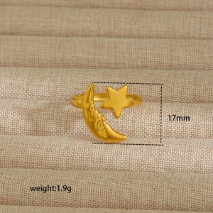 Detailed macro view of 18K gold crescent moon and star ring on a linen jewelry tray