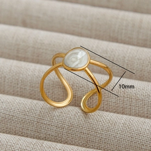 Minimalist gold open ring with 10mm oval white resin inlay on a jewelry tray